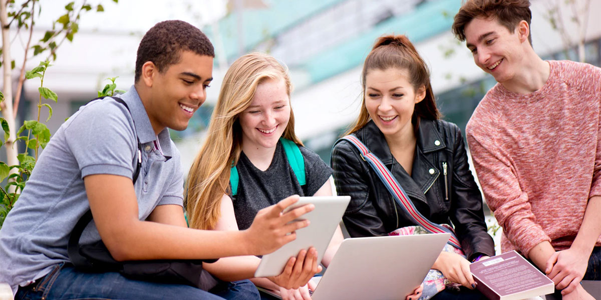 students gathered around laptop