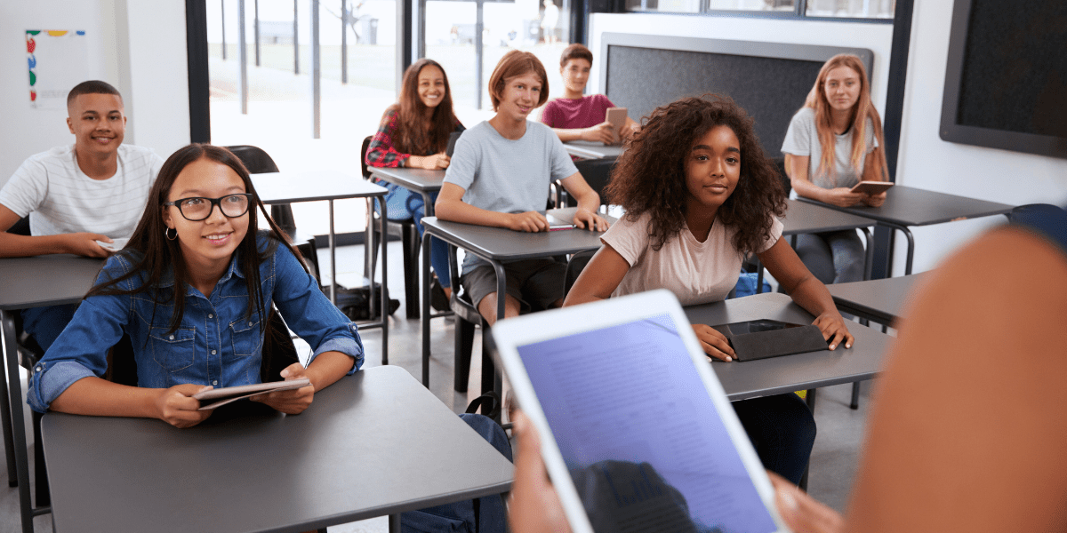 teacher with ipad in front of students